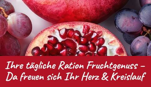 Aufgeschnittener Granatapfel und rote Trauben in Nahaufnahme.