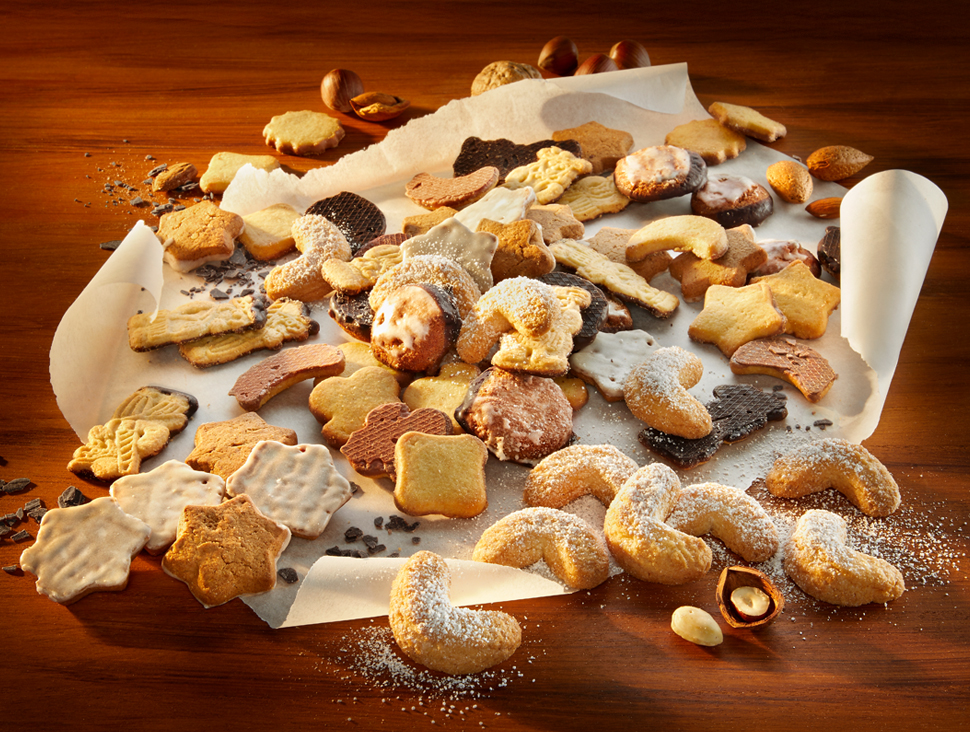 Weihnachtliches Gebäck auf Backpapier mit Puderzucker