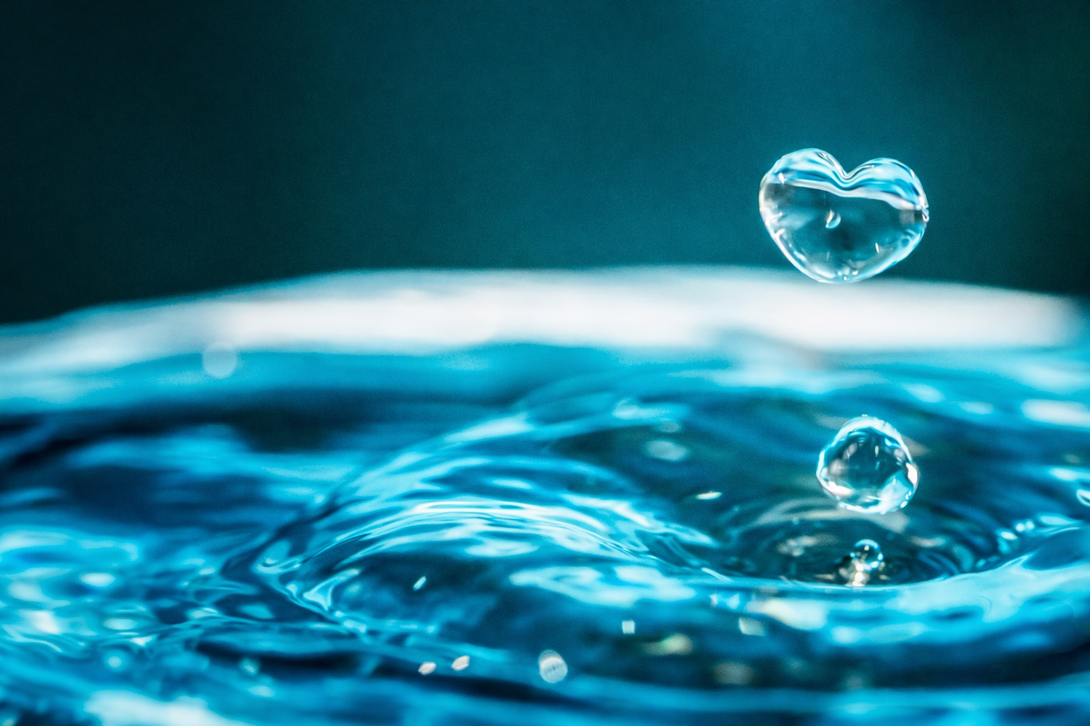 Herzförmiger Wassertropfen über Wasseroberfläche