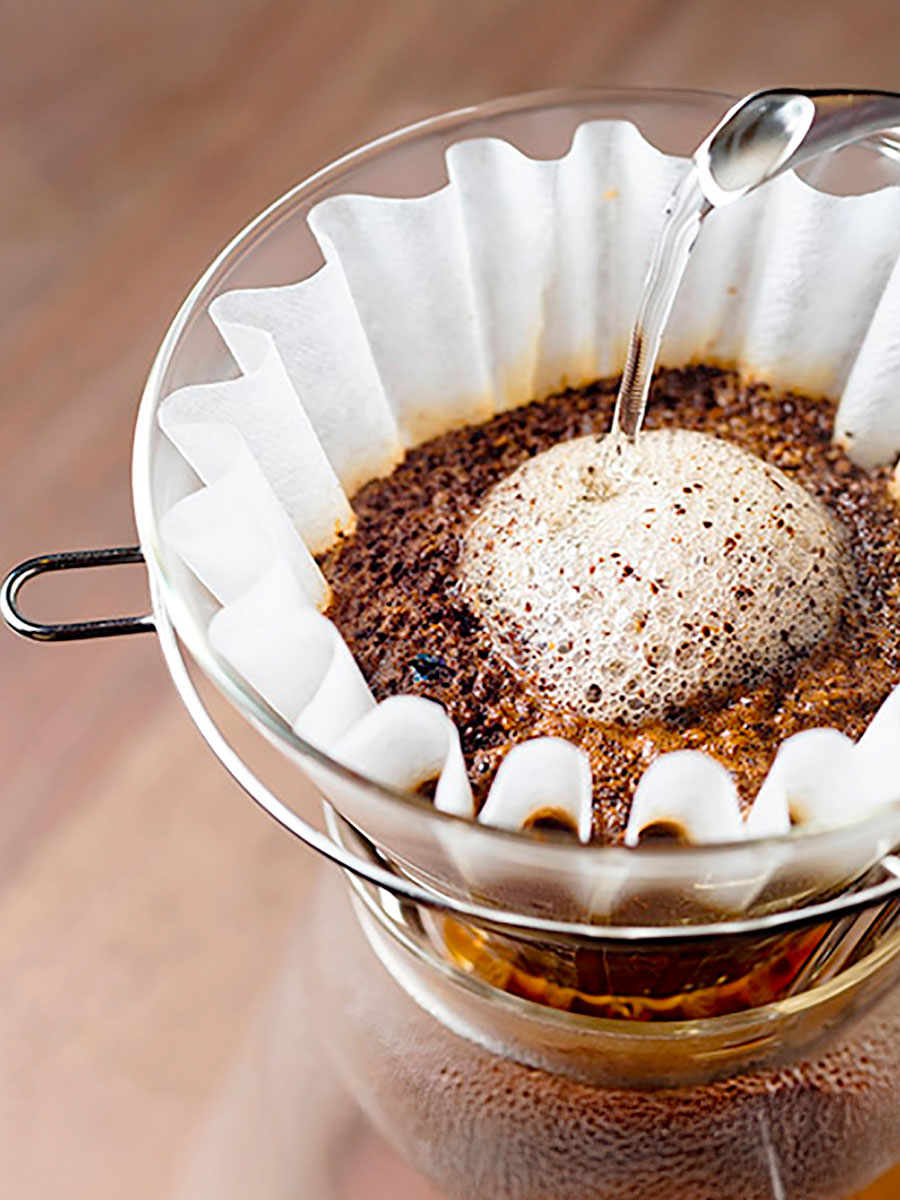 Kaffeefilter mit frisch gebrühtem Kaffee und aufsteigendem Schaum