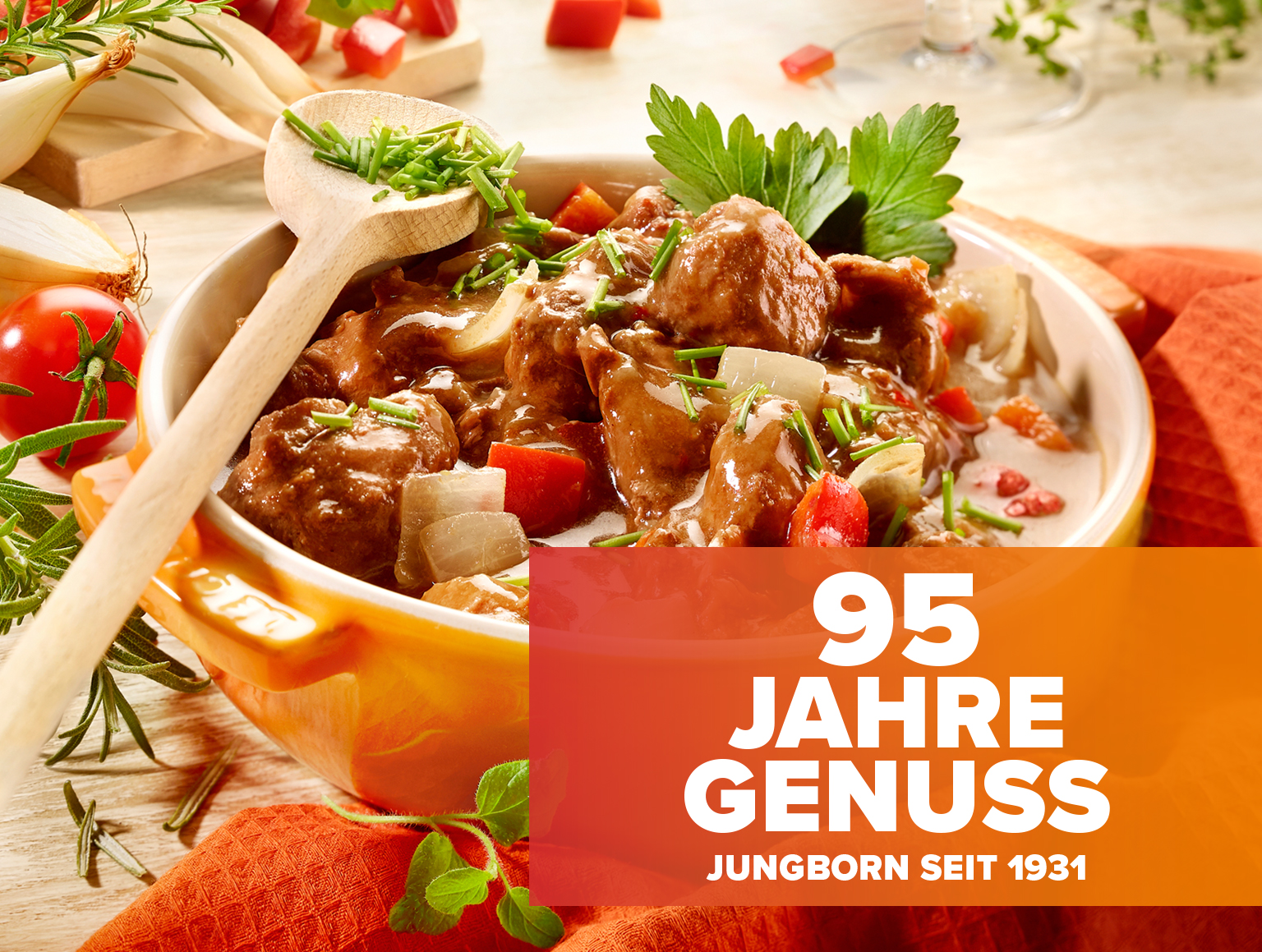 Schmortopf mit herzhaftem Gericht und Schriftzug „95 Jahre Genuss“