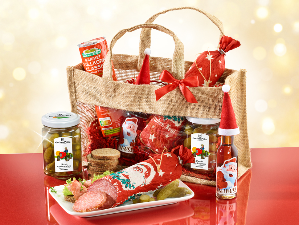 Weihnachtliches Geschenkset mit Wurst, Gurken und Brot im Jutesack