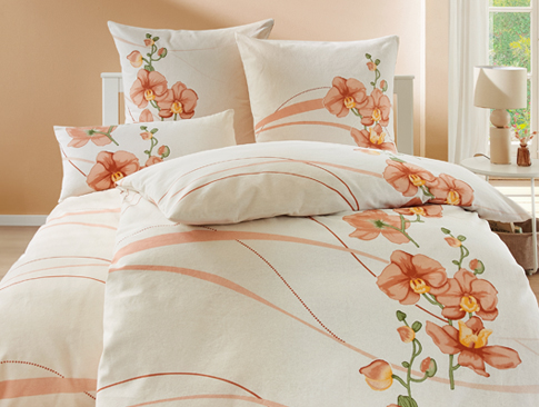 Bettwäsche mit floralen Mustern in warmen Herbsttönen auf einem Bett
