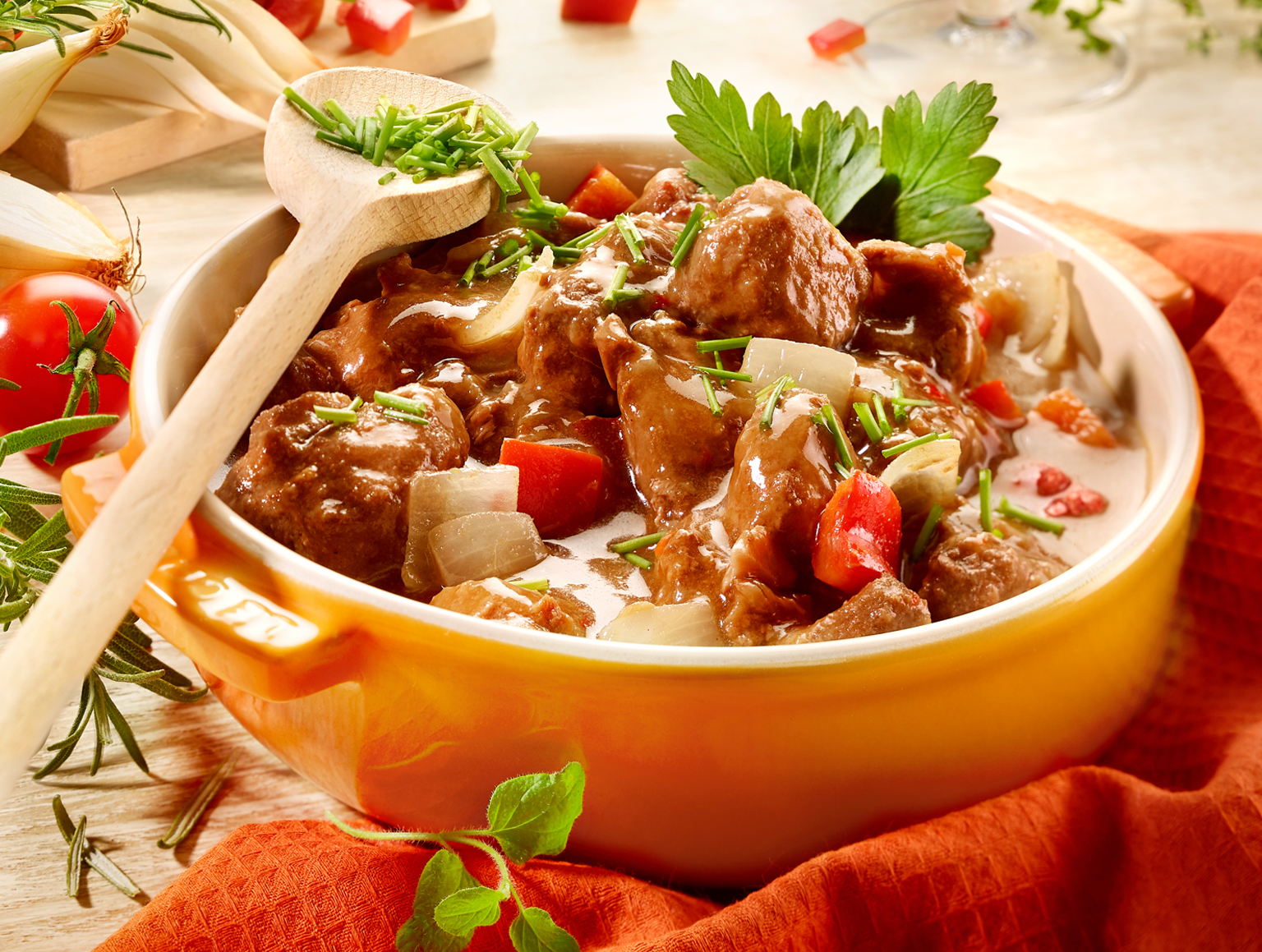 Deftiges Fertiggericht mit Fleisch, Gemüse und Soße in einer Auflaufform.