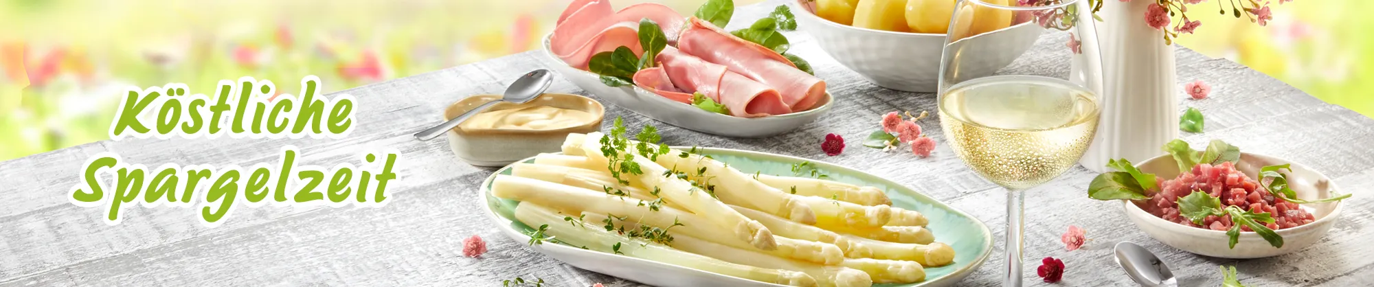 Frischer Spargel mit Schinken, Kartoffeln und Wein auf Frühlingstisch