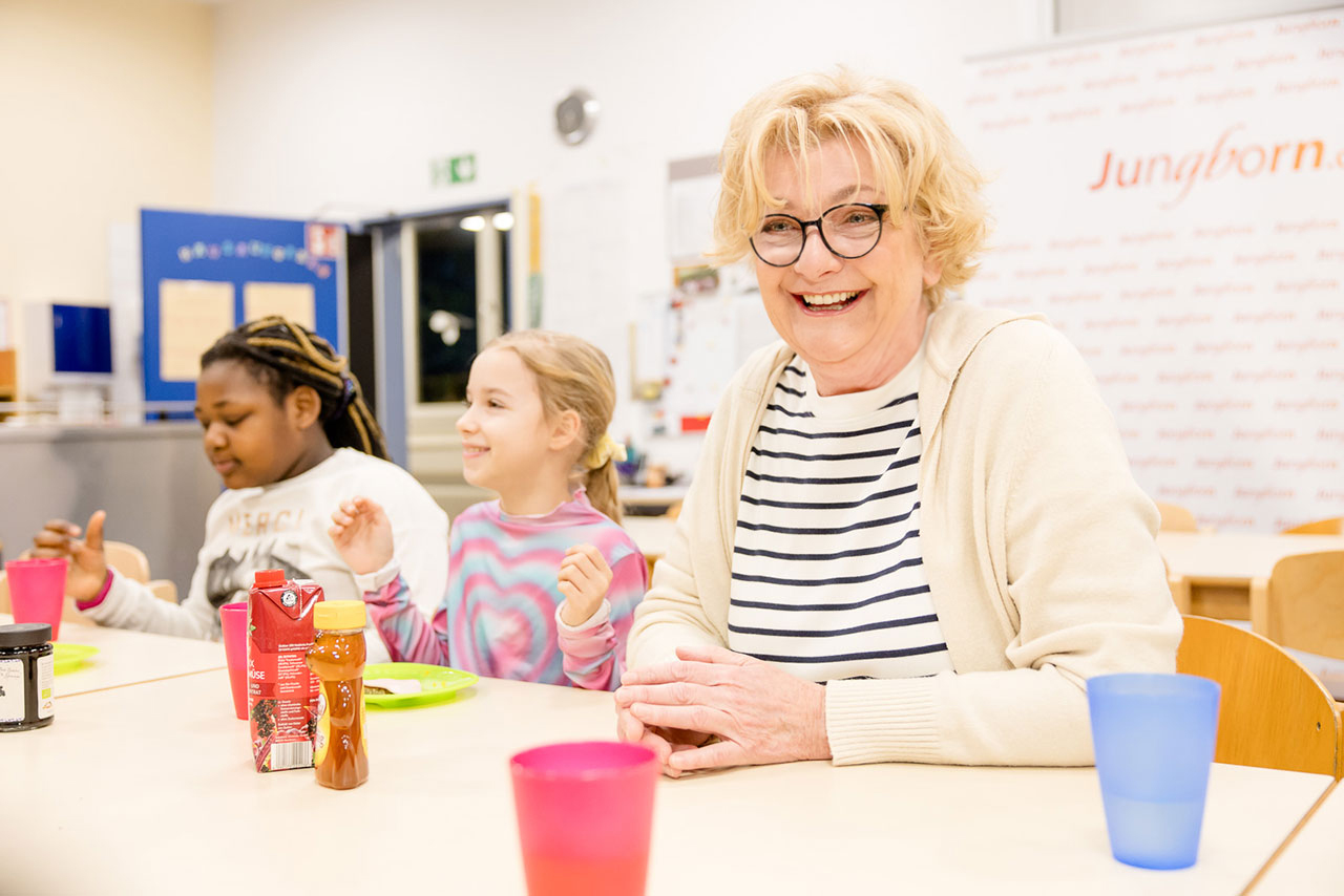 Saskia Vester besucht den Frühstücksklub München und sitzt mit Kindern am Tisch.