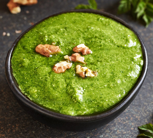 Grünes Spargelpesto mit Walnüssen in einer schwarzen Schale