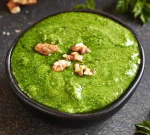 Grünes Spargelpesto mit Walnüssen in einer schwarzen Schale