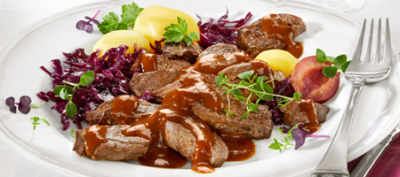 Festliches Gericht mit Braten, Soße, Rotkohl und Kartoffeln