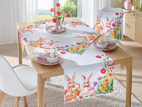 Oster-Tischdecke mit Hasen und Blumen auf gedecktem Tisch