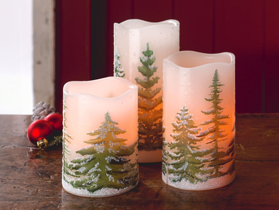 LED-Kerzen mit Tannenbaum-Motiv in winterlicher Optik auf Holztisch