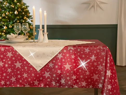 Weihnachtliche Tischwäsche mit Sternenmuster in Rot und Creme, festlich gedeckter Tisch mit Kerzen