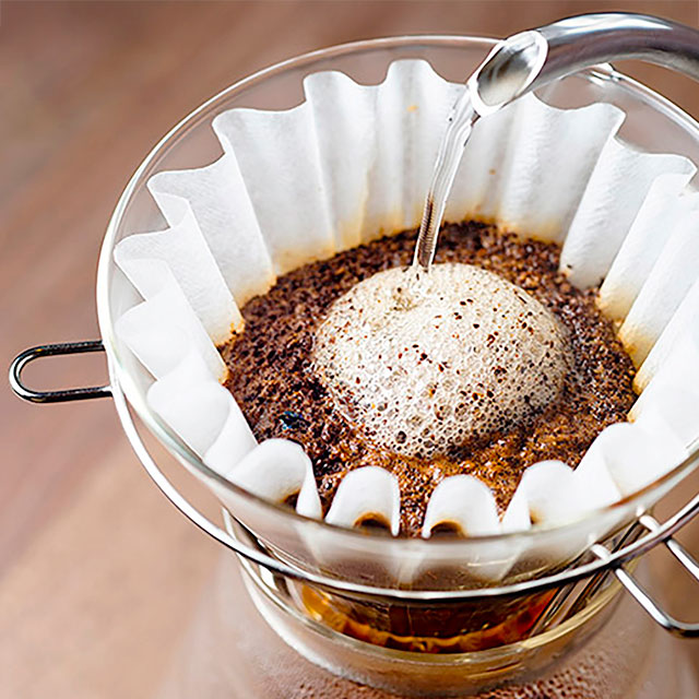 Kaffeefilter mit frisch gebrühtem Kaffee und aufsteigendem Schaum