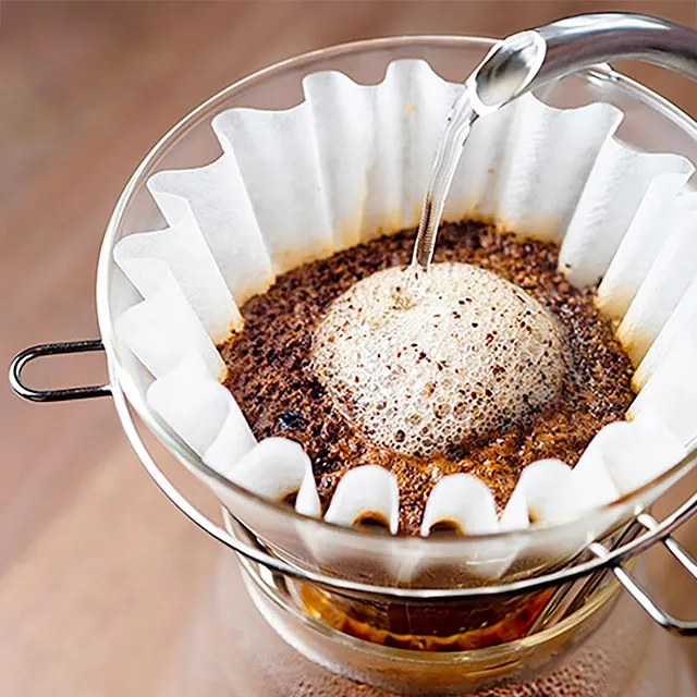 Kaffeefilter mit frisch gebrühtem Kaffee und aufsteigendem Schaum