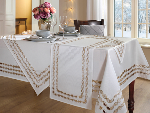 Festlich gedeckter Tisch mit weißer Tischdecke und goldener Bordüre
