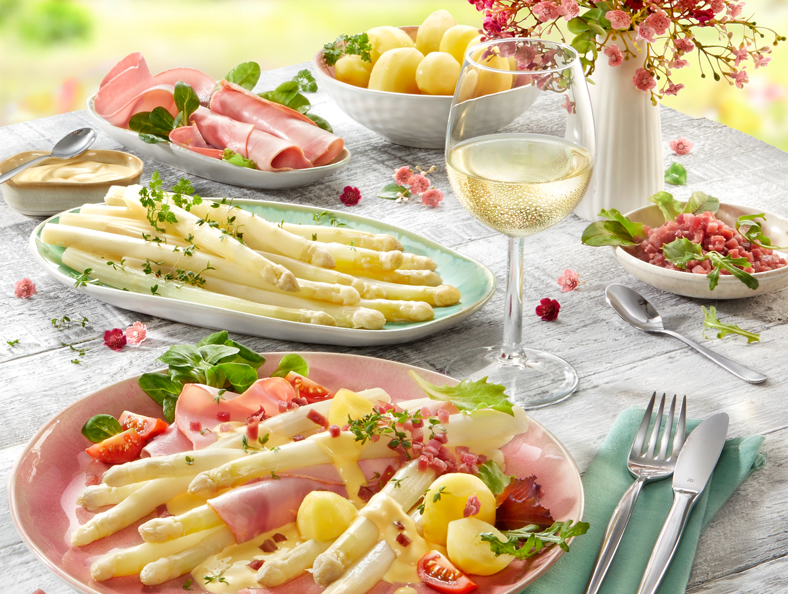 Frischer Spargel mit Schinken, Kartoffeln und Weißwein auf Frühlingsgedeck