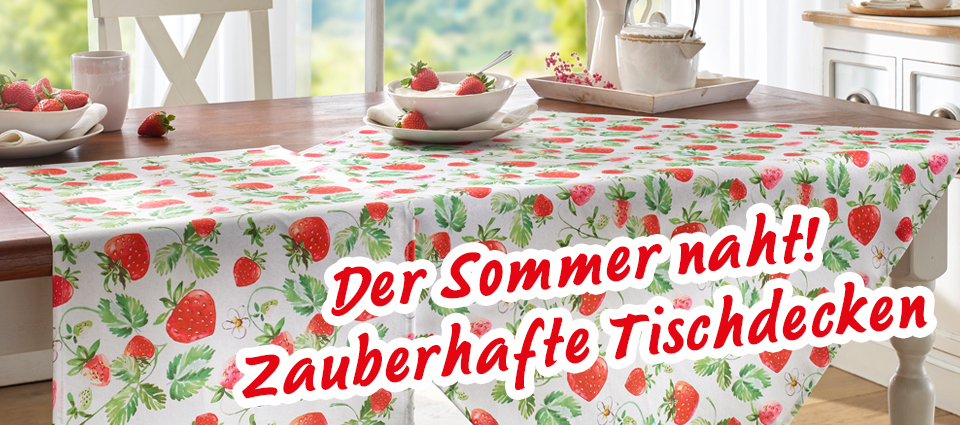 Tischdecke mit Erdbeermotiv auf Holztisch, Geschirr und Erdbeeren als Deko