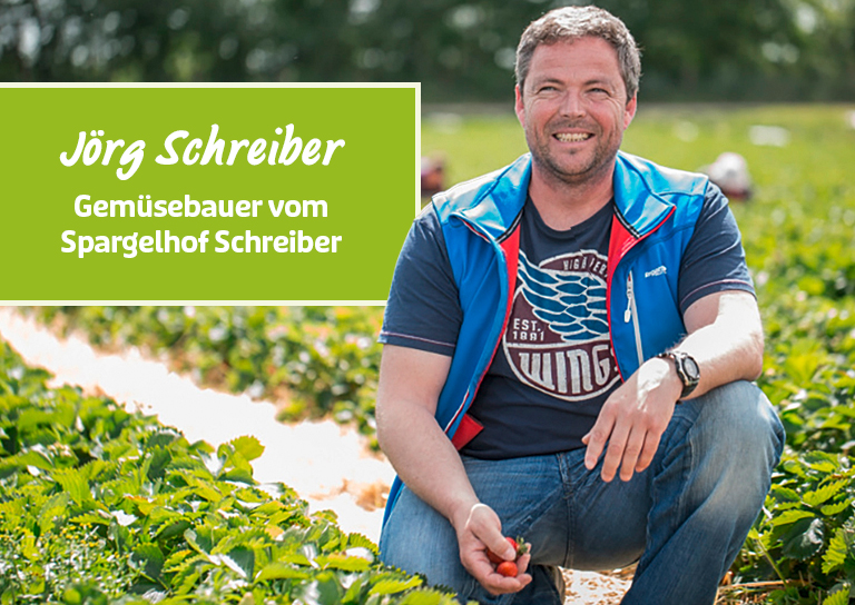 Gemüsebauer sitzt auf dem Feld und lächelt in die Kamera