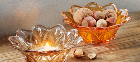 Zwei dekorative Glasschalen mit Nüssen und Kerze