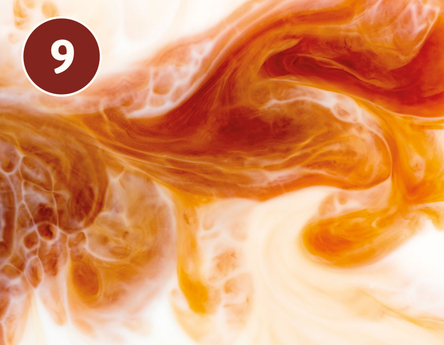 Milch vermischt sich mit Kaffee in Nahaufnahme