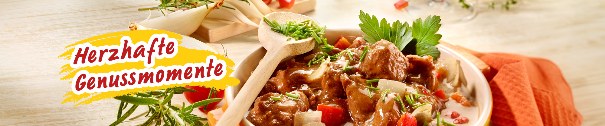 Wiener Schmorgulasch, dekoriert mit frischen Tomaten, Zwiebeln und Kräutern