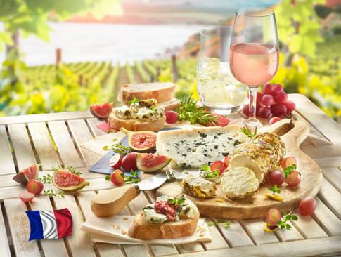 Französische Spezialitäten mit Käse, Baguette, Feigen und Roséwein auf Holztisch.