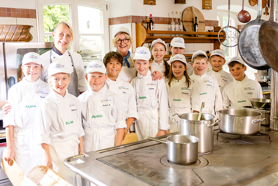 Kinder und Köche kochen gemeinsam in der Miniküche
