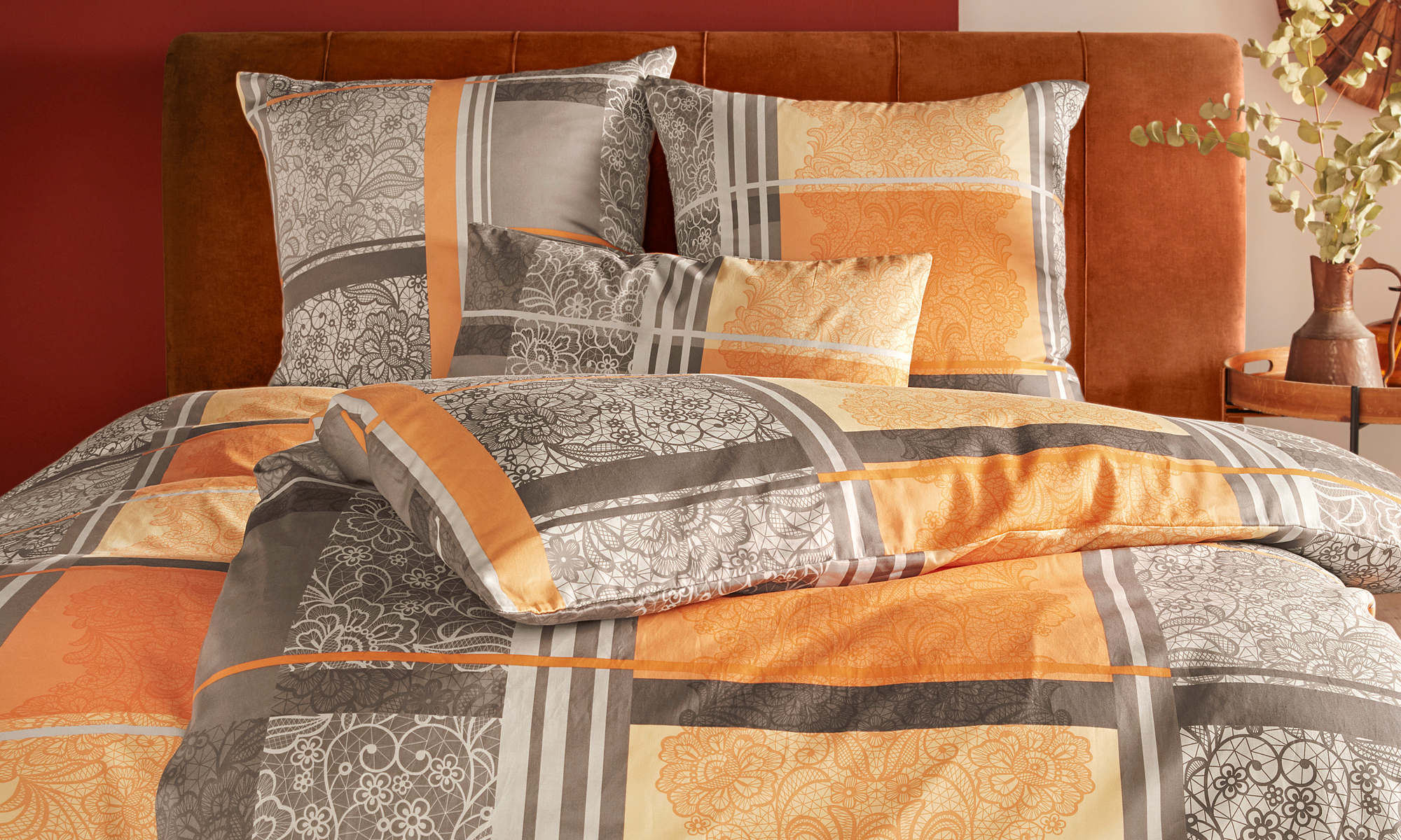 Bettwäsche in Grau und Orange mit Muster, dekorativ aufgemachtes Doppelbett