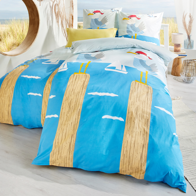 Bettwäsche mit Möwen-Design und maritimen Farben auf einem Bett