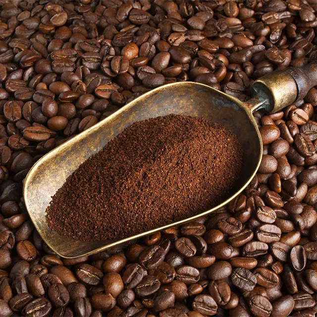 Gemahlener Kaffee in Metallschaufel auf Kaffeebohnen