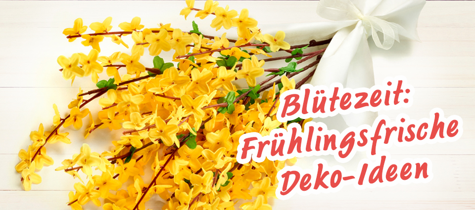 Gelbe Forsythien-Zweige mit weißer Schleife auf hellem Untergrund