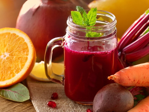 Rote-Bete-Saft im Glas mit frischen Zutaten wie Orange, Karotte und Rote Bete