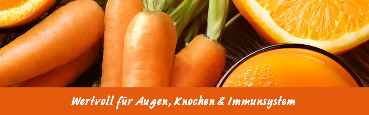 Frische Karotten, Orangen und ein Glas Saft auf natürlichem Untergrund.